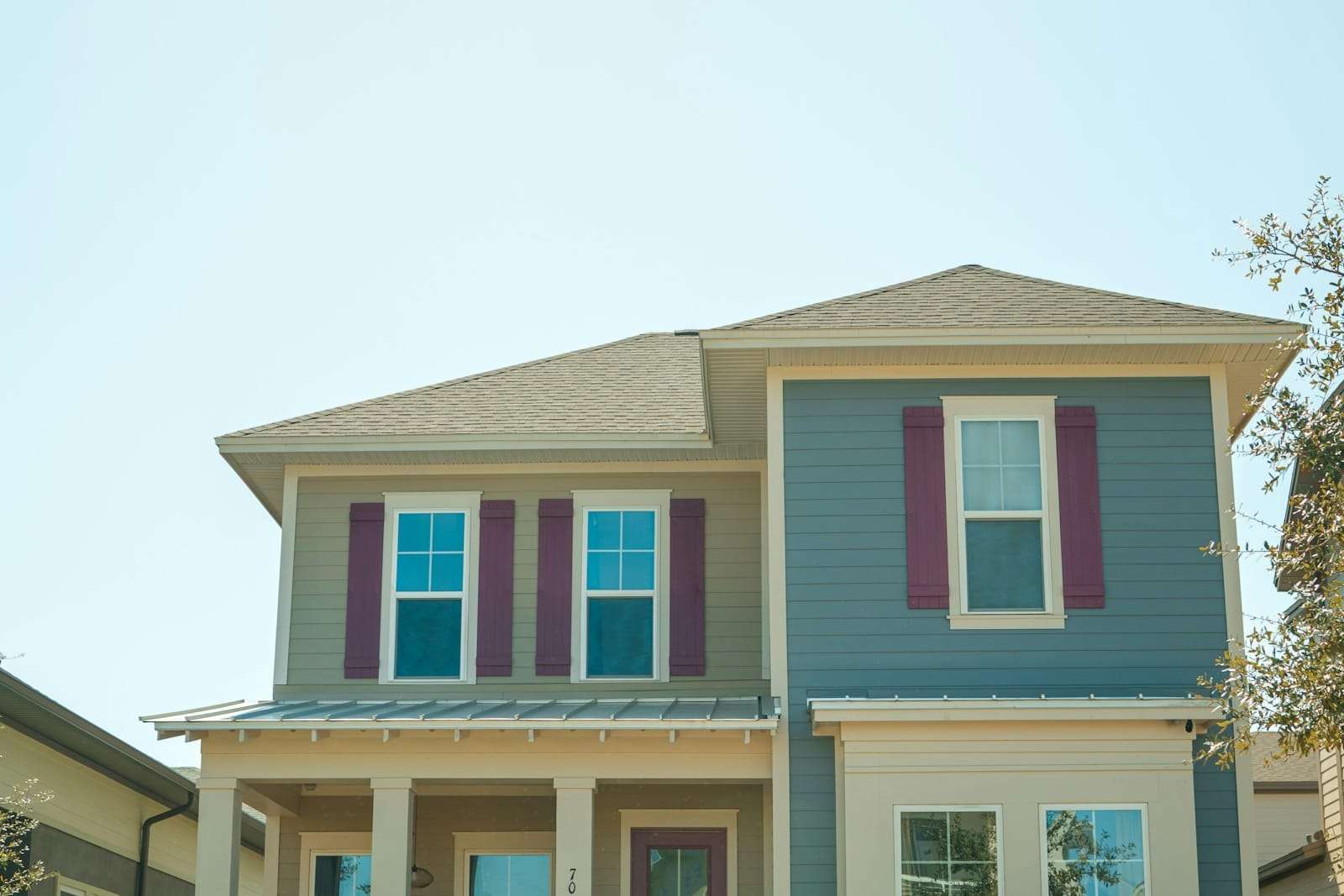 Two-storey house painted blue-grey with white trim and burgundy shutters