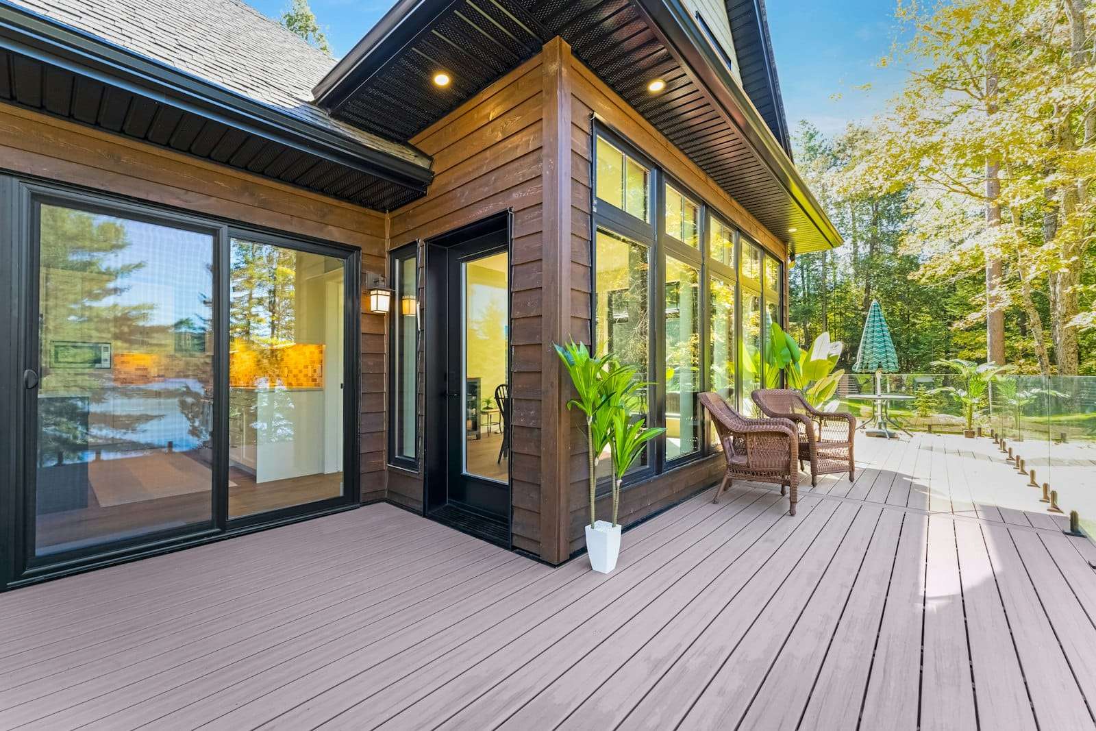 Timber deck with outdoor chairs beside a house clad in stained timber