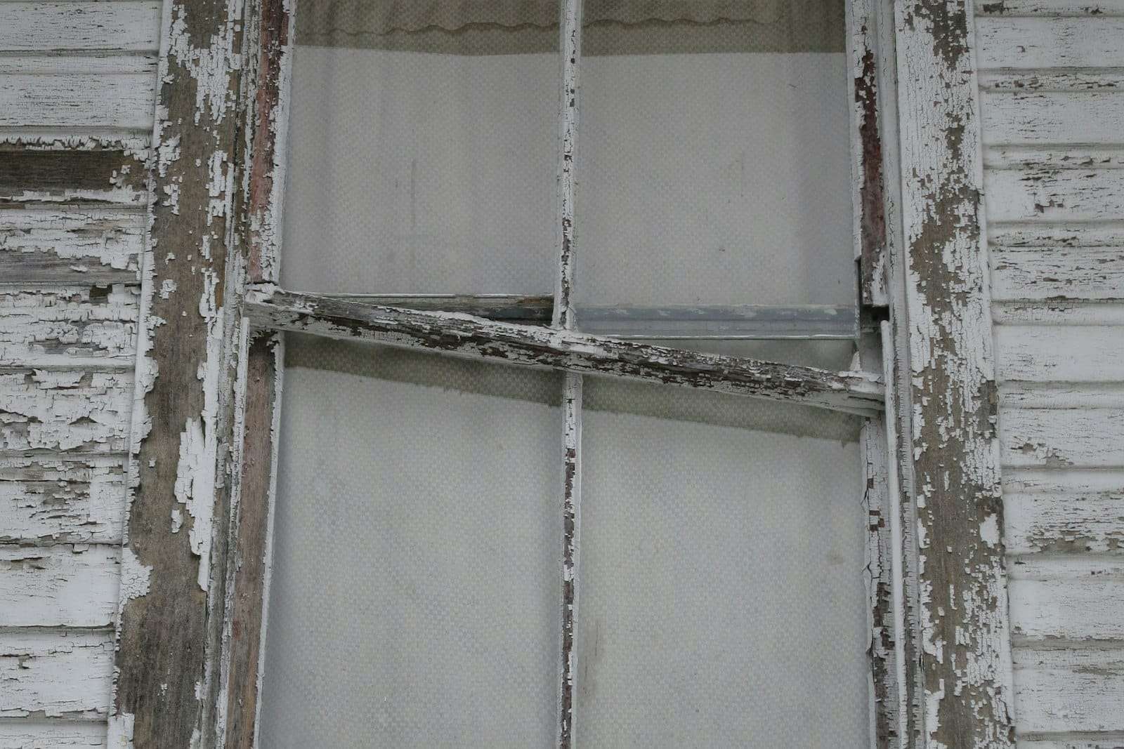 Old timber window frame with flaking white paint