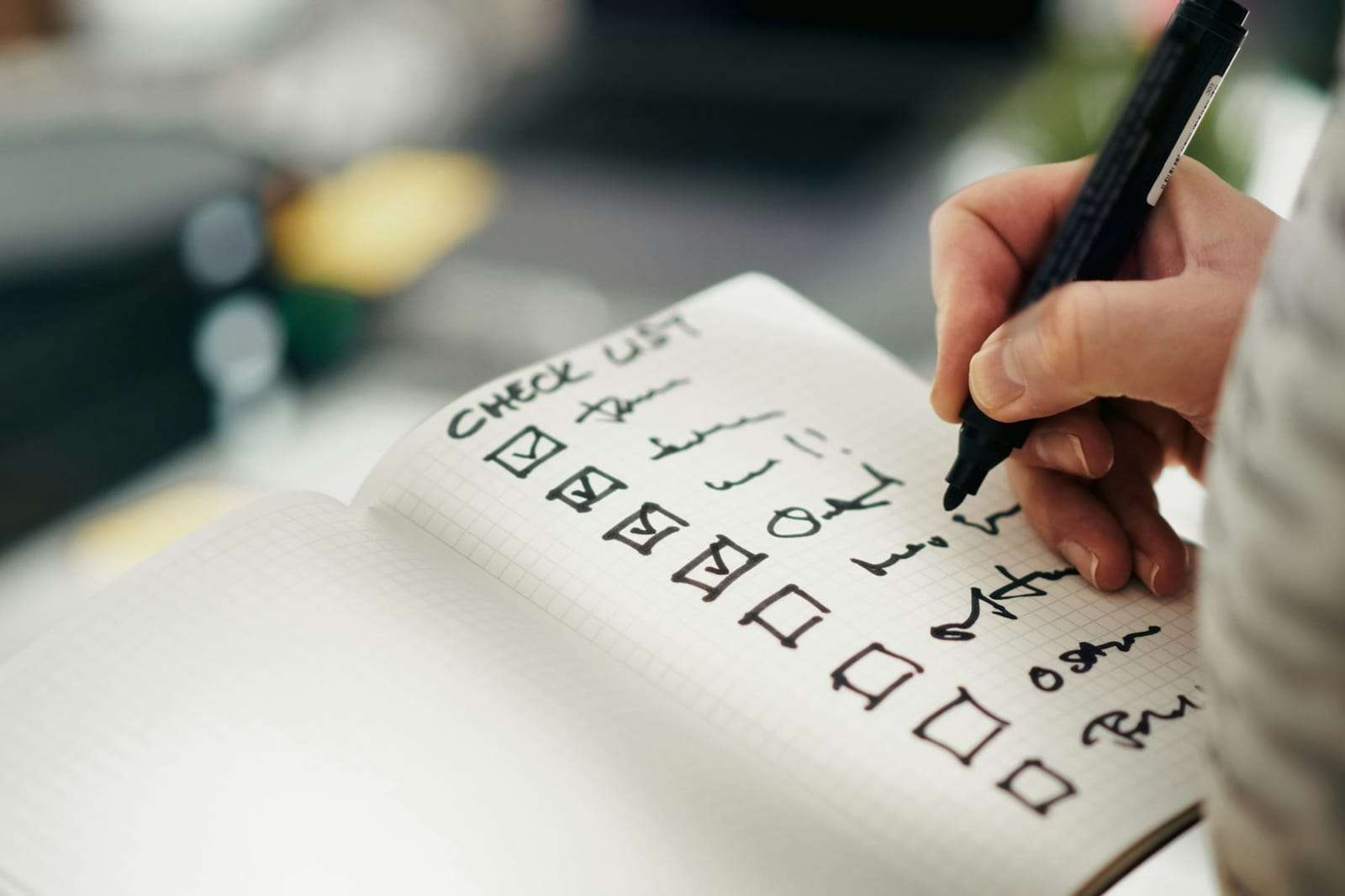Hand ticking items off a handwritten checklist